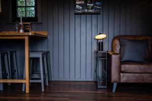 een kamer met een stoel, een tafel en een lamp bij Cherry Tree Lodge in Limavady