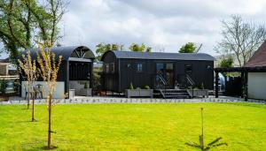 a black tiny house in a yard at Cherry Tree Lodge in Limavady