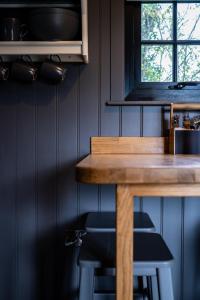 a kitchen with a wooden table and some stools at Cherry Tree Lodge in Limavady