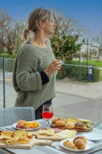 Une femme debout à une table avec de la nourriture sur elle dans l'établissement Hotel Atlas, à Cesenatico