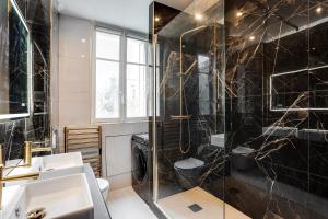 La salle de bains est pourvue d'une douche et d'un lavabo. dans l'établissement Paris’Luxury : Luxe, Calm and Voluptuousness, à Neuilly-sur-Seine