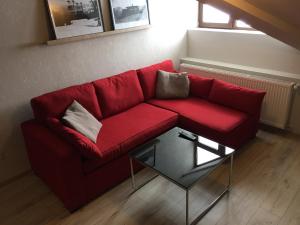 a red couch in a living room with a table at Two Level Apartment near Gondola in Gudauri