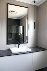 a bathroom with a white sink and a mirror at VILLA MARIS SMRIKA -heated pool in Šmrika