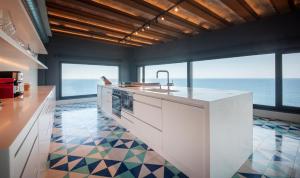 a kitchen with a counter with a view of the ocean at BYPILLOW Cap Sa Sal in Begur