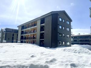 a building with a pile of snow in front of it at Ny leilighet, 2023, sentral beliggenhet ved Highland in Geilo