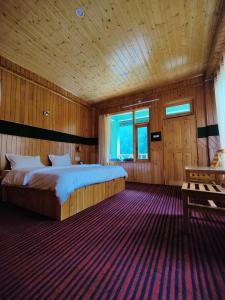 a bedroom with a large bed in a wooden room at The Forest Pinnacle and Café, Jibhi in Jibhi