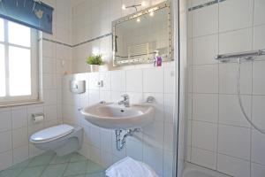 y baño con lavabo, aseo y espejo. en Feriendomizil Goethestraße, Wohnung Strandläufer Whg 15, en Ahlbeck