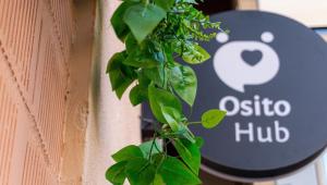 a sign on the side of a building with a plant at Osito Hub - l'Explorador Andrés in Valencia