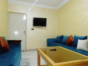 uma sala de estar com um sofá azul e uma televisão em DIAAFATE TANNIRTE em Khenifra