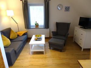 a living room with a couch and a chair and a table at Seeigel in Gruberhagen