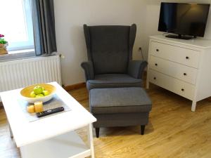 a living room with a chair and a bowl of fruit on a table at Seeigel in Gruberhagen +14 photos