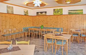 restauracja z drewnianymi ścianami, stołami i krzesłami w obiekcie Stunning Apartment In Neuhausen With Kitchen 