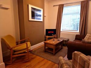 a living room with a couch and a table at Well decorated 2 bed home in Handbridge, Chester in Hough Green