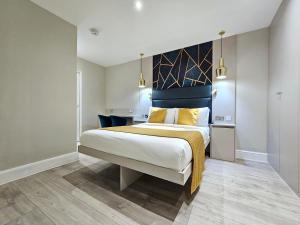 een slaapkamer met een groot bed met gele kussens bij NOX Hyde Park in Londen