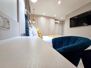 ロンドンにあるNOX Hyde Parkの白い大きなテーブルと青い椅子が備わる客室です。