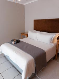 1 dormitorio con 1 cama grande y cabecero marrón en Pecan Farm Guesthouse, en Louis Trichardt