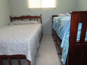 a small bedroom with two beds and a window at Casa Exploradores in Volcán
