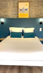 een groot wit bed met 2 kussens in een kamer bij Refuge au Cœur de La Baule in La Baule