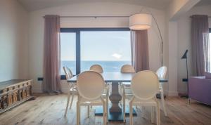 a dining room with a table and chairs and a large window at BYPILLOW Cap Sa Sal in Begur