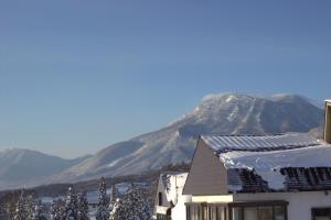 um edifício com uma montanha ao fundo em Hotel Myosen em Myoko