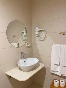 a bathroom with a sink and a mirror and towels at Mareta Beach - Boutique Bed & Breakfast in Sagres