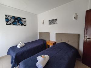 two beds in a room with blue sheets at 4D Torre Rafael - Casas & Papéis in Armação de Pêra