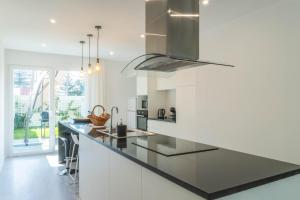 a kitchen with white cabinets and a black counter top at Beach Front Villa in Ponta Delgada