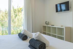 ein Schlafzimmer mit einem Bett mit Handtüchern und einem Fernseher in der Unterkunft Beach Front Villa in Livramento