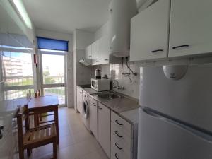 una cucina con frigorifero, lavandino e forno a microonde di 4D Torre Rafael - Casas & Papéis ad Armação de Pêra
