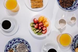 a table with plates of fruit and cups of coffee at Nevma Suites in Firostefani