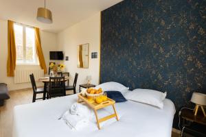 um quarto com uma cama com uma bandeja de frutas em Studio Paon d'Or, 5 minutes du ZooParc de Beauval em Saint-Aignan