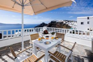 a white table with food on top of a balcony at Nevma Suites in Firostefani