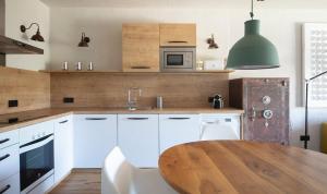 a kitchen with white cabinets and a wooden table at BYPILLOW Cap Sa Sal in Begur