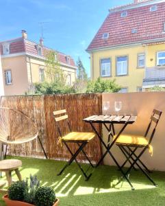 a patio with a table and two chairs and a fence at Appart 2parkings, 2min PetiteVenise-Xmarché in Colmar