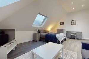 a bedroom with a bed and a tv and a table at LONDON STAY Flats in London