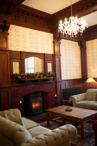 a living room with couches and a fireplace at The Penrallt Country House Hotel in Aberporth