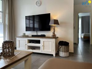 a living room with a flat screen tv on a white cabinet at Villa Vivaldi Ferienwohnung 2 in Wangerooge