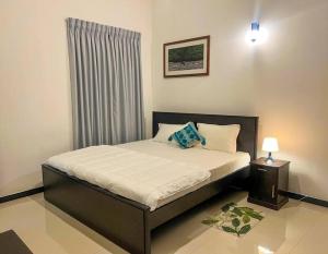 a bedroom with a bed with a window and a bed sidx sidx sidx at Cactus Piliyandala in Piliyandala