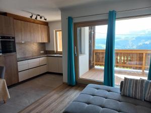 a kitchen with a couch and a large sliding glass door at Schießling Hof in Oberndorf in Tirol
