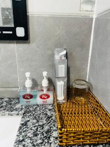 un bagno con due bottiglie di acqua potabile e un cesto giallo di KHÁCH SẠN HOÀNG QUANG a Biđong