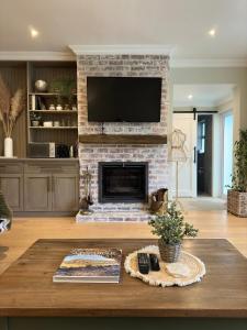 Camellia Cottage - Bay Room في كيب تاون: غرفة معيشة مع موقد حجري مع تلفزيون بشاشة مسطحة