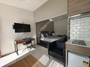 a hotel room with a bed and a desk and a television at Altair Motel in Cooma