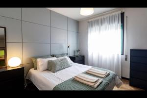 a bedroom with a bed with towels on it at Três Marias by LovelyStay in Aver-o-Mar