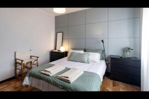 a bedroom with a bed with towels on it at Três Marias by LovelyStay in Aver-o-Mar