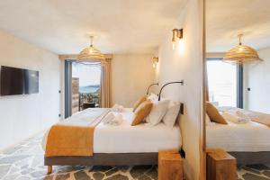 Habitación con 2 camas, TV y ventanas. en Le Domaine de la mer - Beach hotel Nature&Authenticité Hyères, en Hyères