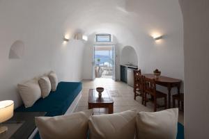 a living room with a blue couch and a table at Nevma Suites in Firostefani