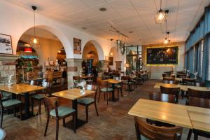 un restaurante con mesas y sillas de madera y un bar en Trail-Inn Natur & Sporthotel en Berdorf