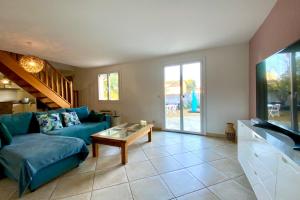 ein Wohnzimmer mit einem blauen Sofa und einem Tisch in der Unterkunft La Castelnauvienne- 3 bedroom villa with swimming pool! in Castelnau-le-Lez