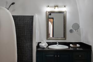 a bathroom with a sink and a mirror at Nevma Suites in Firostefani