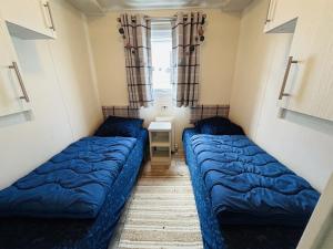 2 Betten in einem kleinen Zimmer mit Fenster in der Unterkunft Beach Resort Nieuwvliet-Bad 1240 - EEZZ in Nieuwvliet